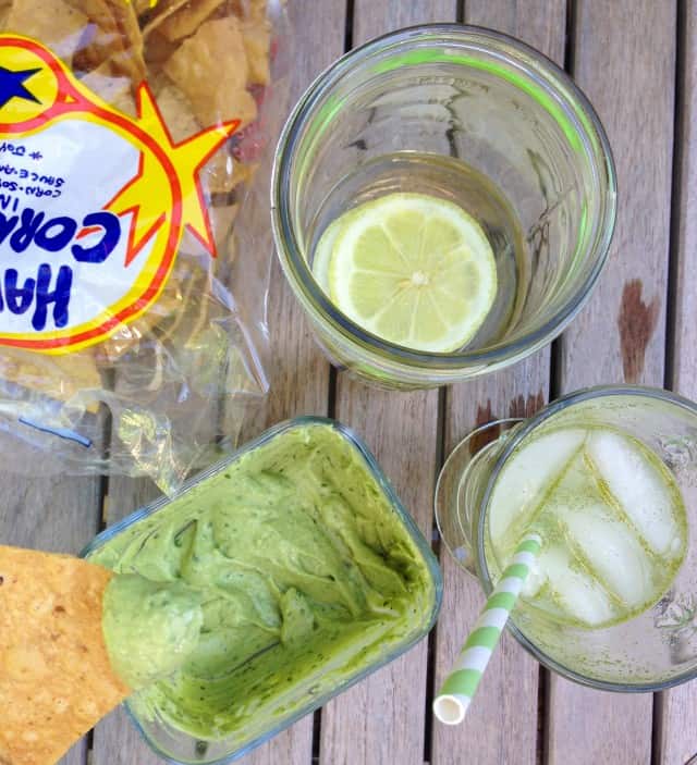 avocado tahini dip with chips and drink