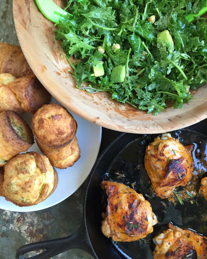 baby kale salad with oven roasted sriracha chicken thighs and rosemary and sea salt popvers