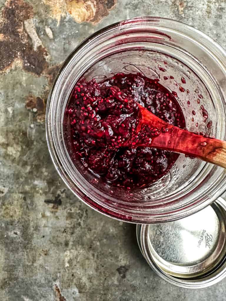 Blackberry chia compote cooling in a jar.