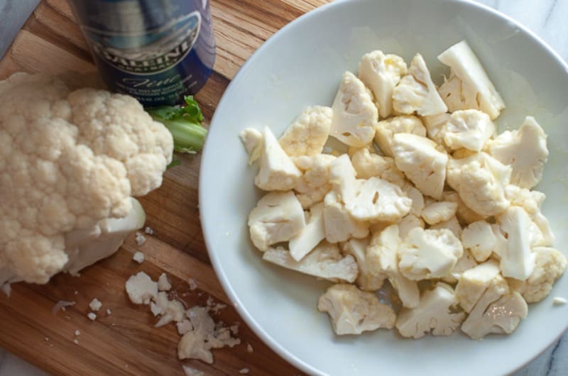 Cauliflower tossed with olive oil and sea salt in a bowl