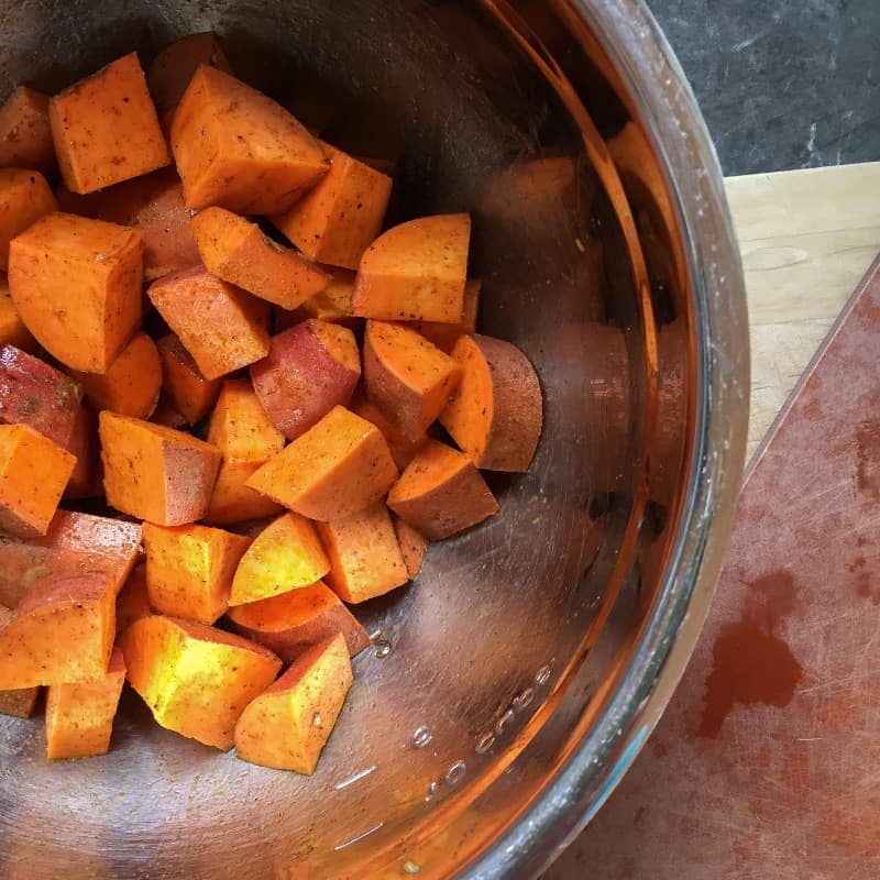 Cubed sweet potatoes mixed with olive oil and chili powder