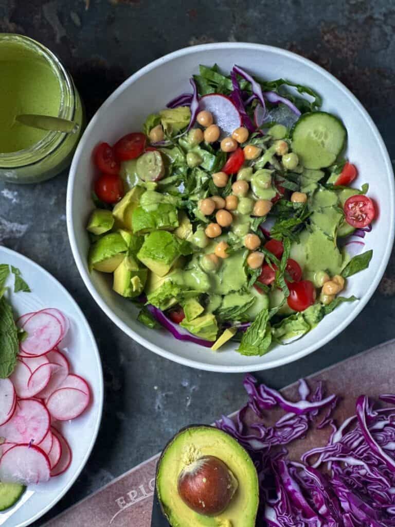 Dairy free green goddess dressing drizzled over a salad.