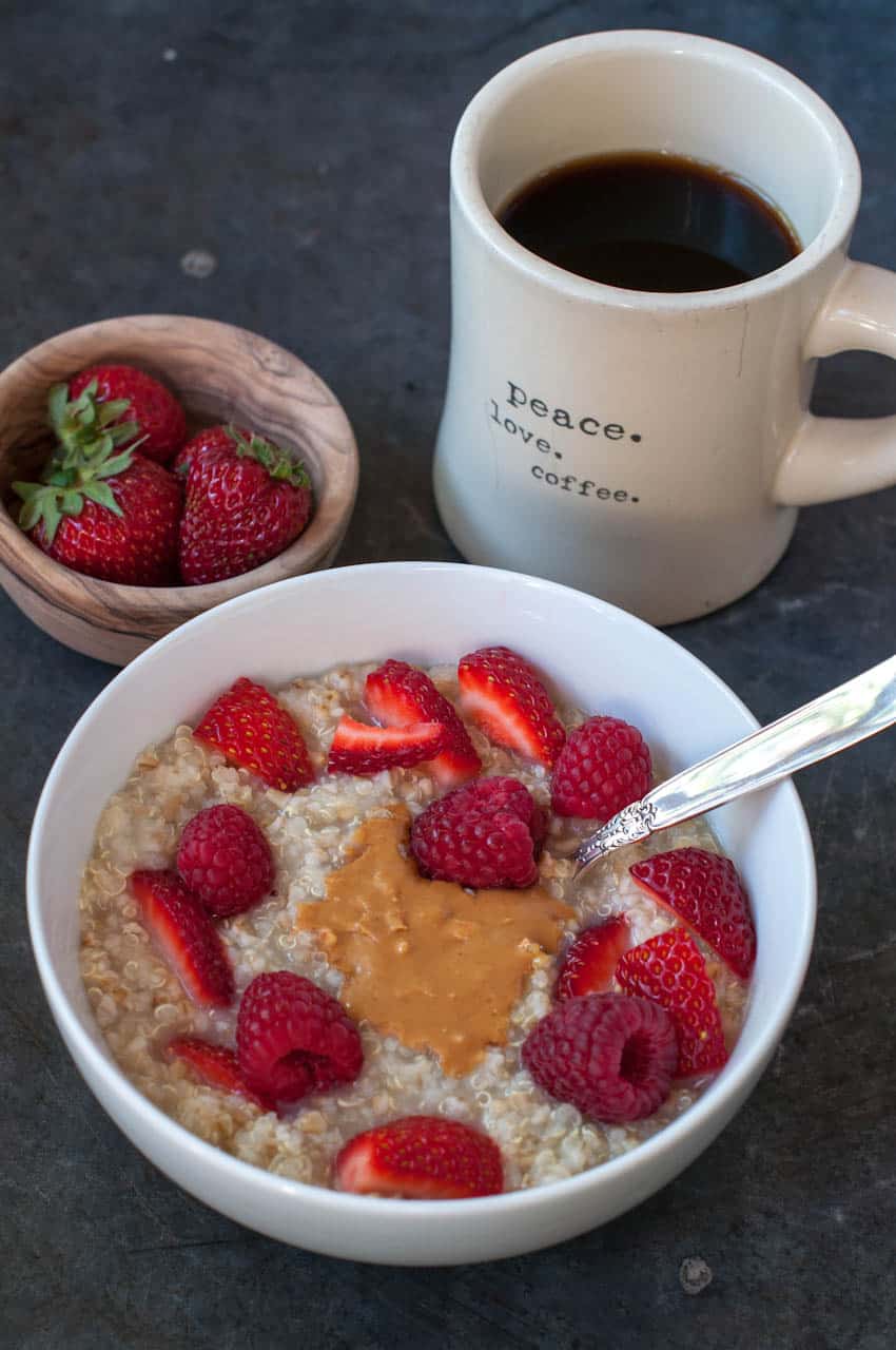 Easy overnight hot quinoa and steel cut oats in a bowl next to coffee