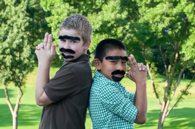 Eli and friend wearing many fake mustaches