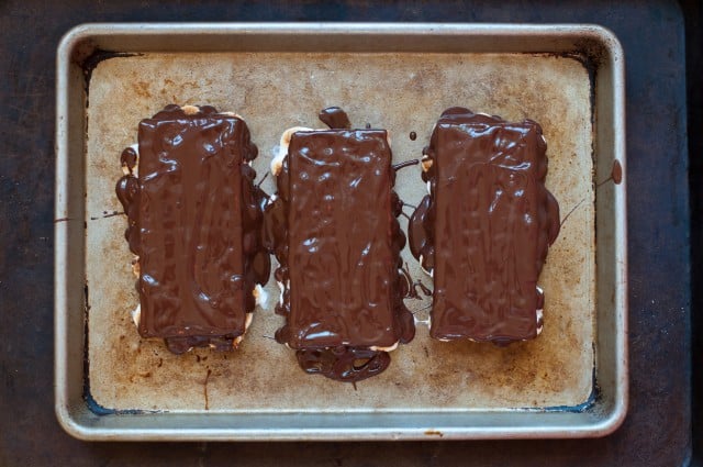 frozen s'mores covered with chocolate on baking sheet