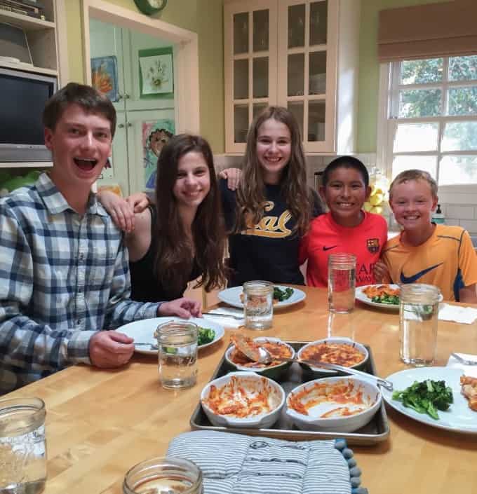 Happy kids around table of food