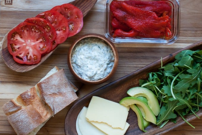 ingredients for roasted red pepper arugula avocado and tomato panini