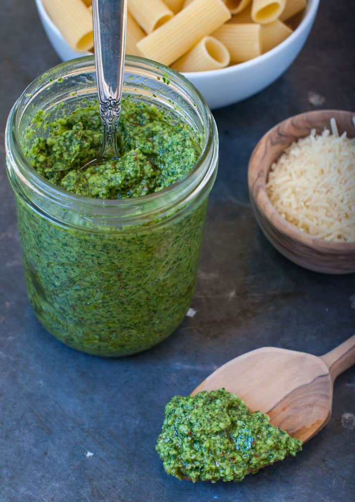 Kale spinach and basil pesto in a jar with a spoon