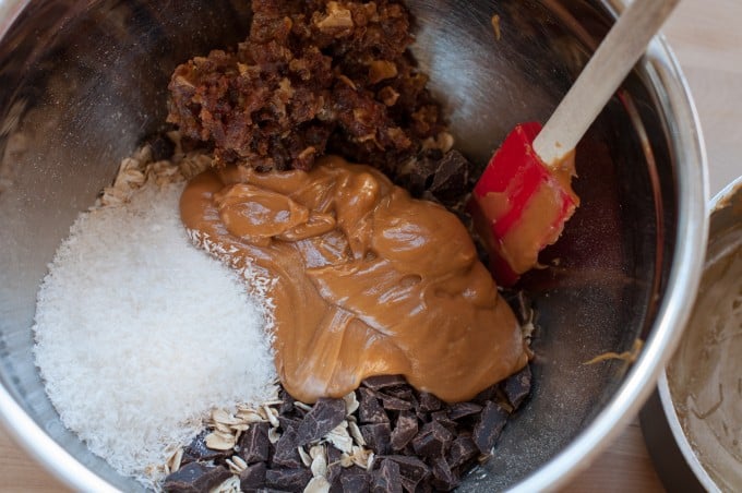 Peanut butter dates chocolate coconut and oats in a bowl with spatula