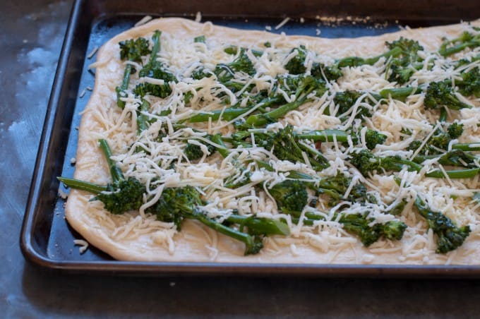 Pizza topped with broccoli rabe and cheese