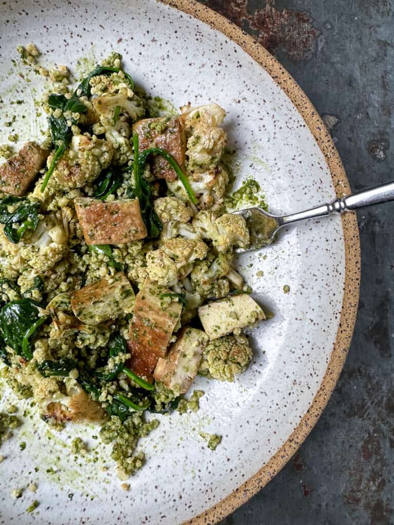 Quick and easy sautéed tofu paired with roasted cauliflower, pesto and millet.