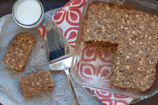 Quinoa snack bars in a pan with pieces cut out and on the table.