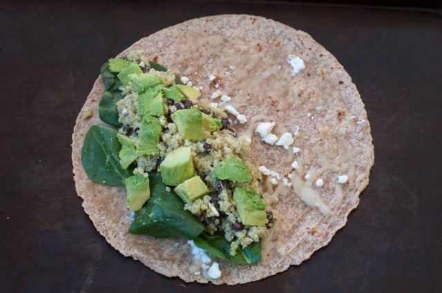 Taking the cheesy tortilla and placing it on a plate.  Top the tortilla with some spinach.