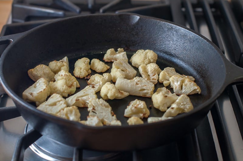Roasted cauliflower in a skillet on the stove