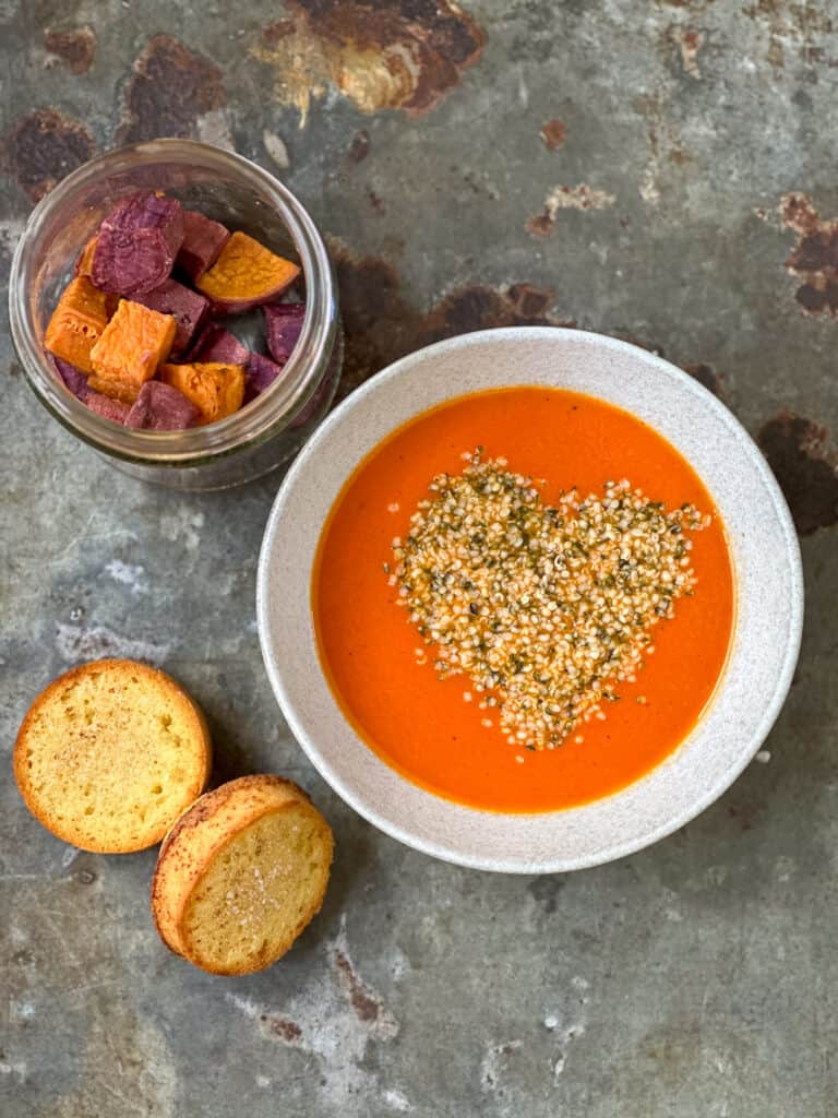 Roasted red pepper and tomato soup topped with hemp seeds.