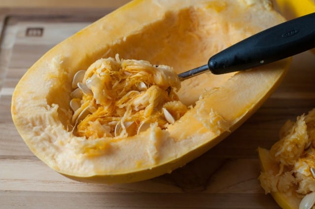Scooping out spaghetti squash seeds