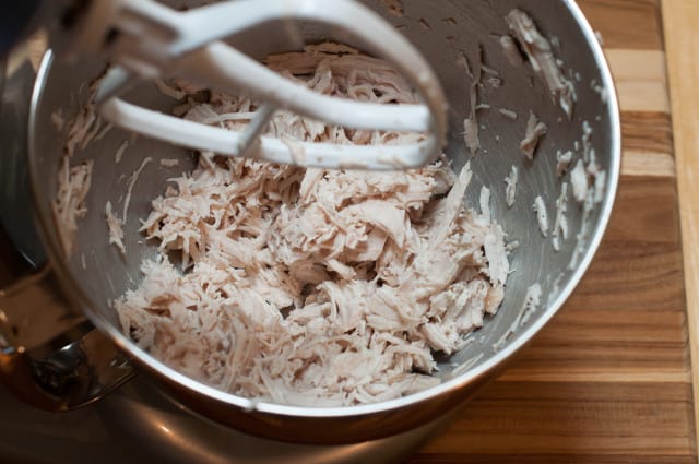 Shredded chicken in a mixer with paddle