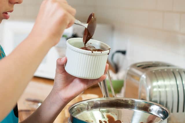 Pouring chocolate into dish with ice cream