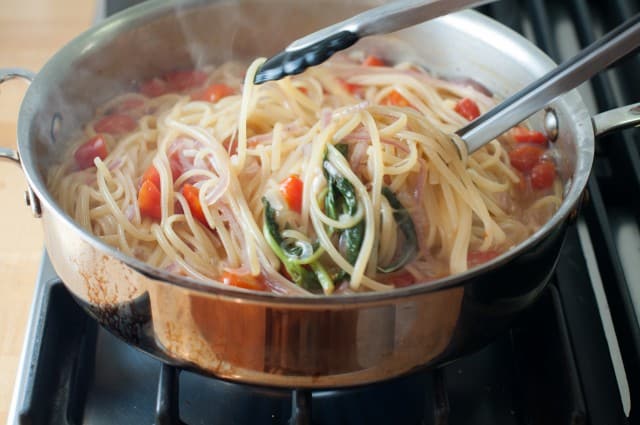 tossing pasta in pot
