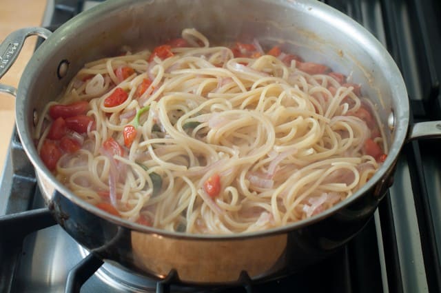tossing pasta in pot