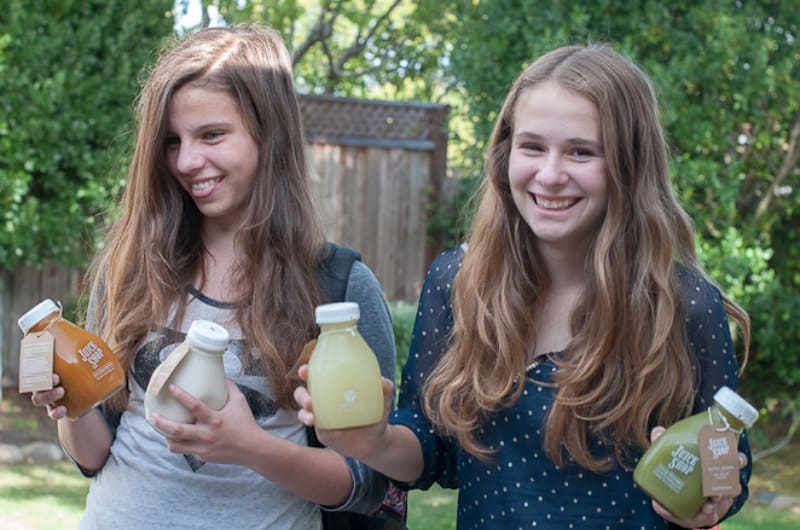 Young girls holding juice bottles
