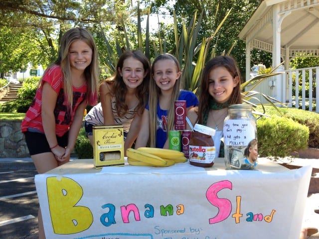 Young girls running banana stand